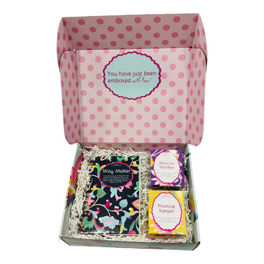 Gift box with polka dot lid containing three books titled 'Way Maker', 'Miracle Worker', and 'Promise Keeper'.